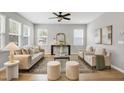 Bright living room features hardwood floors, modern furniture, and plenty of natural light at 127 S Harrison Place Ln, Fuquay Varina, NC 27526