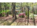 Beautiful home nestled amongst mature trees with vibrant azaleas in the front yard at 1309 Wakefield Farm Rd, Zebulon, NC 27597