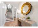Inviting entryway with wooden staircase, patterned wallpaper, decorative mirror and table at 1317 Garner Rd # 101, Raleigh, NC 27610
