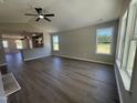 Open-concept living room with sleek hard surface floors, a ceiling fan, and ample natural light from large windows at 163 Grace Pond Ave, Benson, NC 27504