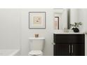 Cozy bathroom with decorative art, modern fixtures, and dark wood vanity, enhanced by a plant and a window at 1717 Goldfinch Perch Ln, Knightdale, NC 27545