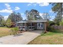 This single-story brick home features a covered porch and a long driveway at 1800 Tee Dee St, Raleigh, NC 27610