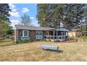 A cozy single-story brick home with a covered front porch, shutters and a well-manicured front lawn at 1800 Tee Dee St, Raleigh, NC 27610