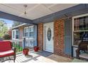 A cozy front porch with outdoor seating, brick accents, and a decorative front door at 1800 Tee Dee St, Raleigh, NC 27610