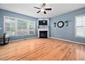 Bright living room with hardwood floors, fireplace, and large windows at 2001 Lilly Brook St, Fuquay Varina, NC 27526