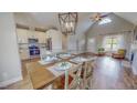 Open-concept kitchen/living area with hardwood floors, stainless appliances, granite counters, and vaulted ceilings at 2540 Levi Ln, Bahama, NC 27503