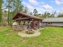 Outdoor entertainment area featuring a built-in kitchen, wood burning fireplace, and seating at 2920 Ode Turner Rd, Hillsborough, NC 27278