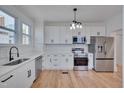 Bright kitchen features white cabinets, stainless steel appliances, white subway tile backsplash and hardwood floors at 301 E Umstead St, Durham, NC 27707