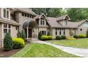 Welcoming stone entrance with landscaped lawn, shrubs, and trees at 301 Stone Currie Dr, Hillsborough, NC 27278