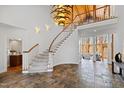 Grand foyer featuring a curved staircase, slate flooring, and an elegant chandelier at 301 Stone Currie Dr, Hillsborough, NC 27278