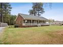 Welcoming single-story home featuring a large front porch, neat lawn, and attractive brick and siding exterior at 3026 Shoeheel Rd, Kenly, NC 27542
