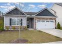 Traditional single-story home featuring stone accents and a two-car garage at 303 Azalea Gaze Dr, Youngsville, NC 27596
