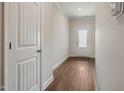 Well-lit hallway with white doors, wood-look flooring, and modern trim, offering a clean and inviting transition space at 303 Azalea Gaze Dr, Youngsville, NC 27596