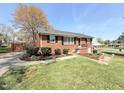 Well-kept brick home with a green lawn, tidy landscape, and paved driveway at 310 Meadowbrook Dr, Burlington, NC 27215