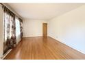 Sunlit living room features gleaming hardwood floors and neutral wall paint at 310 Meadowbrook Dr, Burlington, NC 27215