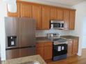 Modern kitchen with stainless steel appliances, wooden cabinets, and granite countertops at 3537 Layton Ridge Dr, Apex, NC 27539
