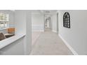 Bright hallway featuring tile flooring and neutral paint, leading to various rooms in the home at 408 Indian Elm Ln, Cary, NC 27519