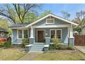 Charming blue craftsman home featuring a cozy front porch with brick accents and inviting curb appeal at 410 N Hyde Park Ave, Durham, NC 27703