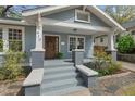 Inviting front porch featuring painted steps, brick columns, and wood door at 410 N Hyde Park Ave, Durham, NC 27703