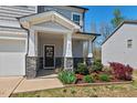 Inviting front porch with stone accents and a beautifully landscaped garden bed at 433 Mockingbird Ln, Mebane, NC 27302