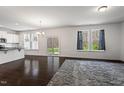 Open-concept living room with hardwood floors, abundant natural light, and access to the backyard at 433 Mockingbird Ln, Mebane, NC 27302