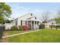 Exterior view of a charming home showcasing a screened porch and landscaped yard at 440 S Church St, Coats, NC 27521