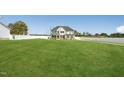 Expansive front yard view of a two-story home with white vinyl fencing at 45 Pond Mountain Dr, Clayton, NC 27520