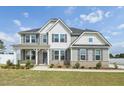 Charming two-story home featuring gray siding, dark shutters, and manicured landscaping at 45 Pond Mountain Dr, Clayton, NC 27520