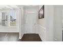 Bright foyer featuring beautiful wainscoting, hardwood floors, a window and a white front door at 45 Pond Mountain Dr, Clayton, NC 27520