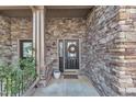 Covered entrance with a wreath on the door and stone detail surrounding the door at 4801 Glenmist Ct # 202, Raleigh, NC 27612
