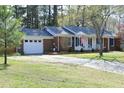 Charming one-story home featuring a brick facade, blue shutters, and a long driveway at 5520 Mccormick Rd, Durham, NC 27713