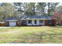 Charming one-story home featuring a brick facade, blue shutters, and a well-manicured front lawn at 5520 Mccormick Rd, Durham, NC 27713