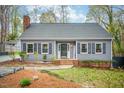 Inviting gray home with black shutters, brick accents, and manicured landscaping enhancing curb appeal at 5608 Ventura Dr, Durham, NC 27712