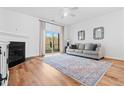 Bright living room featuring a fireplace, wood floors, area rug, and sliding glass doors at 5980 Osprey Cove Dr, Raleigh, NC 27604