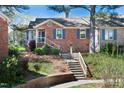 Charming brick home featuring blue shutters, a bay window, a manicured lawn, and inviting front steps at 6 Preakness Dr, Durham, NC 27713