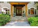 Close up view of the home's inviting entrance, including stone steps and lush plantings at 6016 Glenthorne Dr, Raleigh, NC 27613