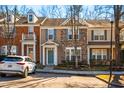 Street view of townhomes featuring brick, neutral siding and blue accents at 602 Walnut Woods Dr # 62, Morrisville, NC 27560
