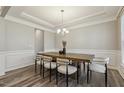 Elegant dining room featuring a modern chandelier, hardwood floors, and wainscoting at 705 Marshall Farm St, Wake Forest, NC 27587