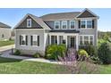 Charming two-story home with manicured lawn and flowering tree in the foreground at 834 November Ln, Willow Springs, NC 27592