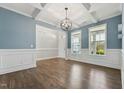 Open-concept living area with beautiful hardwood floors, white trim, and a modern chandelier at 834 November Ln, Willow Springs, NC 27592