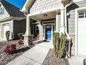 Welcoming entryway with a blue front door, stone accents, and manicured bushes at 103 Thornwhistle Pl, Garner, NC 27529
