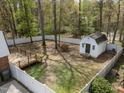 Large fenced backyard featuring a shed, a deck, mature trees providing shade, and a well-maintained lawn at 1108 Medlin Dr, Cary, NC 27511