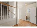 Inviting foyer featuring hardwood floors, staircase, and entry to a bathroom at 1116 Silky Dogwood Trl, Apex, NC 27502