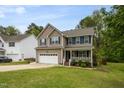 Charming two-story home with blue shutters, manicured lawn and an attached two-car garage at 136 Ashlyn Ridge Dr, Garner, NC 27529