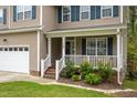 Close-up of a home's front porch with white railings, landscaping, and a welcoming entrance at 136 Ashlyn Ridge Dr, Garner, NC 27529