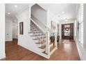 Bright foyer with hardwood floors, a staircase with dark iron balusters, and natural light at 144 Arabella Ct, Cary, NC 27518