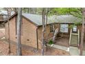 Brick home exterior featuring multiple entryways surrounded by mature trees at 200 W Woodcroft Pkwy # 37A, Durham, NC 27713