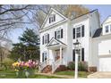 Charming two-story home with black shutters, beautiful lawn, decorative hanging flower baskets, and inviting entryway at 2061 Carriage Way, Chapel Hill, NC 27517