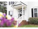Inviting front porch with brick steps, white railings, and a glass front door at 2061 at 2061 Carriage Way, Chapel Hill, NC 27517