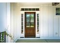 Charming front door with sidelights and transom window, offering a warm welcome at 2075 Toad Hollow Trl, Apex, NC 27502